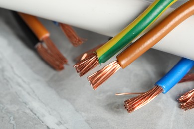 Photo of Colorful electrical wires on gray textured surface, closeup