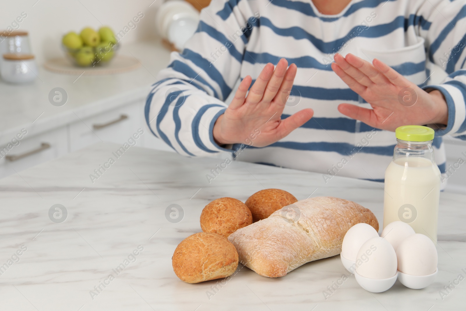 Photo of Woman suffering from food allergies refusing eat different fresh products at light marble table indoors, closeup