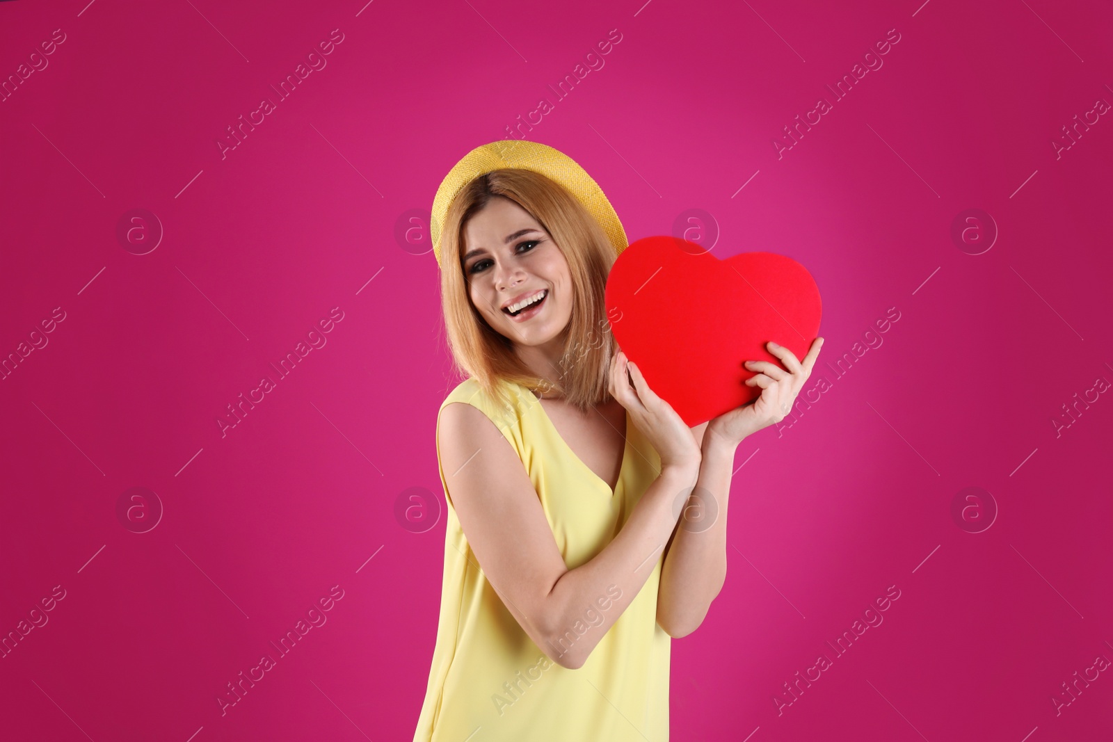 Photo of Beautiful woman with paper heart on color background