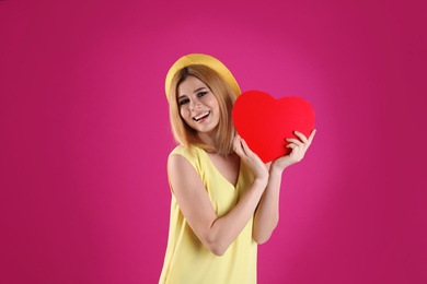 Photo of Beautiful woman with paper heart on color background
