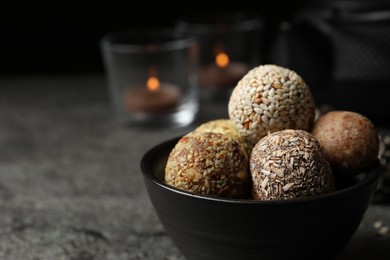 Delicious vegan candy balls on grey table, closeup. Space for text