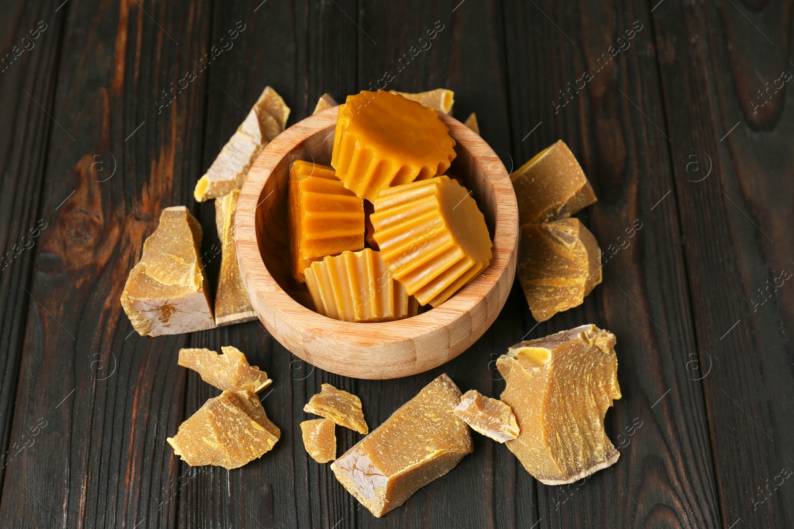 Photo of Different natural beeswax blocks on wooden table, above view