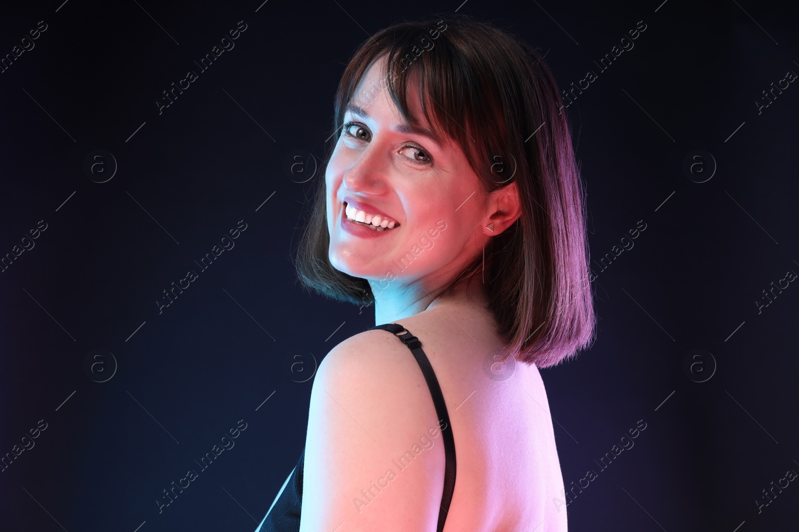 Photo of Portrait of happy woman on dark background