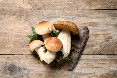 Photo of Flat lay composition with porcini mushrooms on wooden table