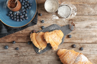 Photo of Tasty croissants served for breakfast on wooden table