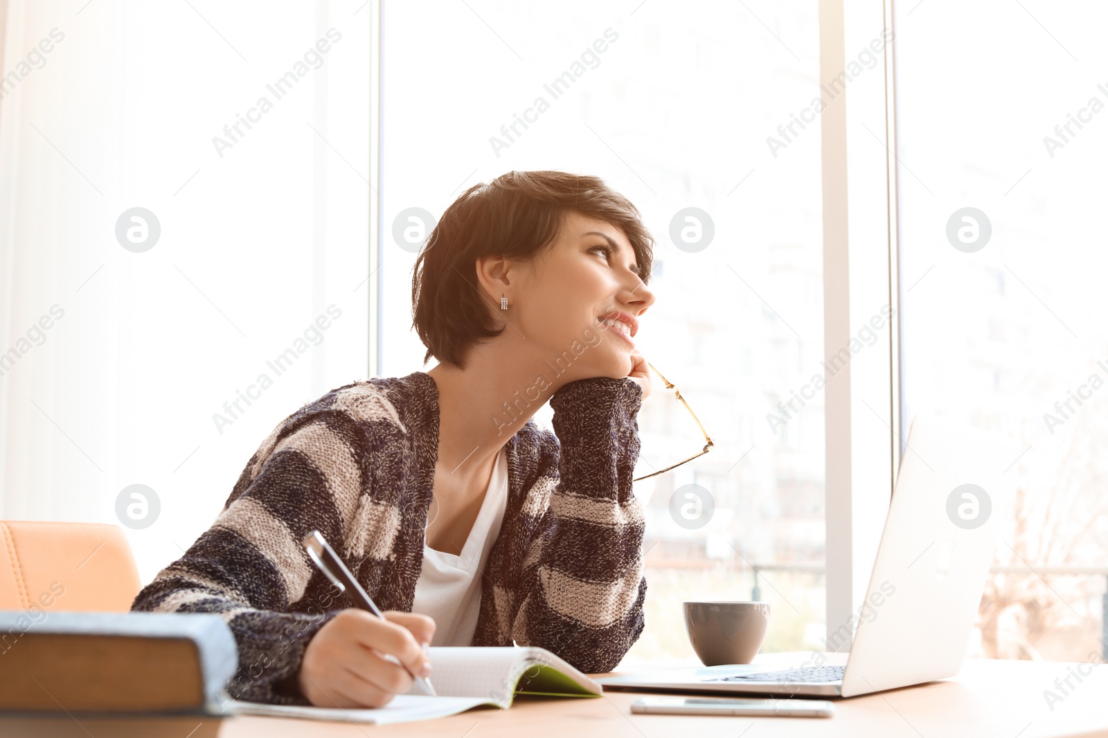 Photo of Young woman working at desk. Home office