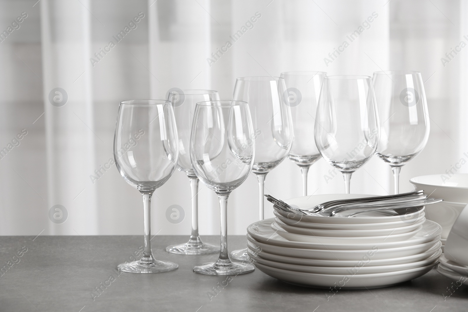 Photo of Set of clean dishes on the table against blurred background