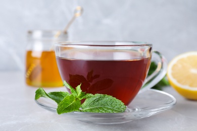 Photo of Fresh tea with mint on light table, closeup