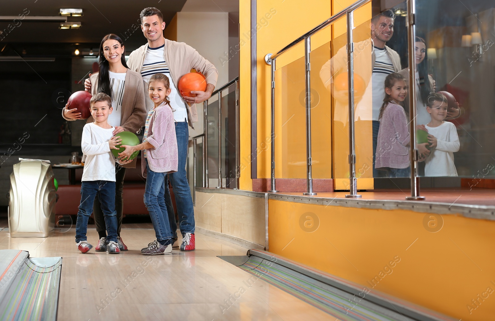 Photo of Happy family spending time together in bowling club