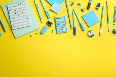 Photo of Blue school stationery on yellow background, flat lay with space for text. Back to school