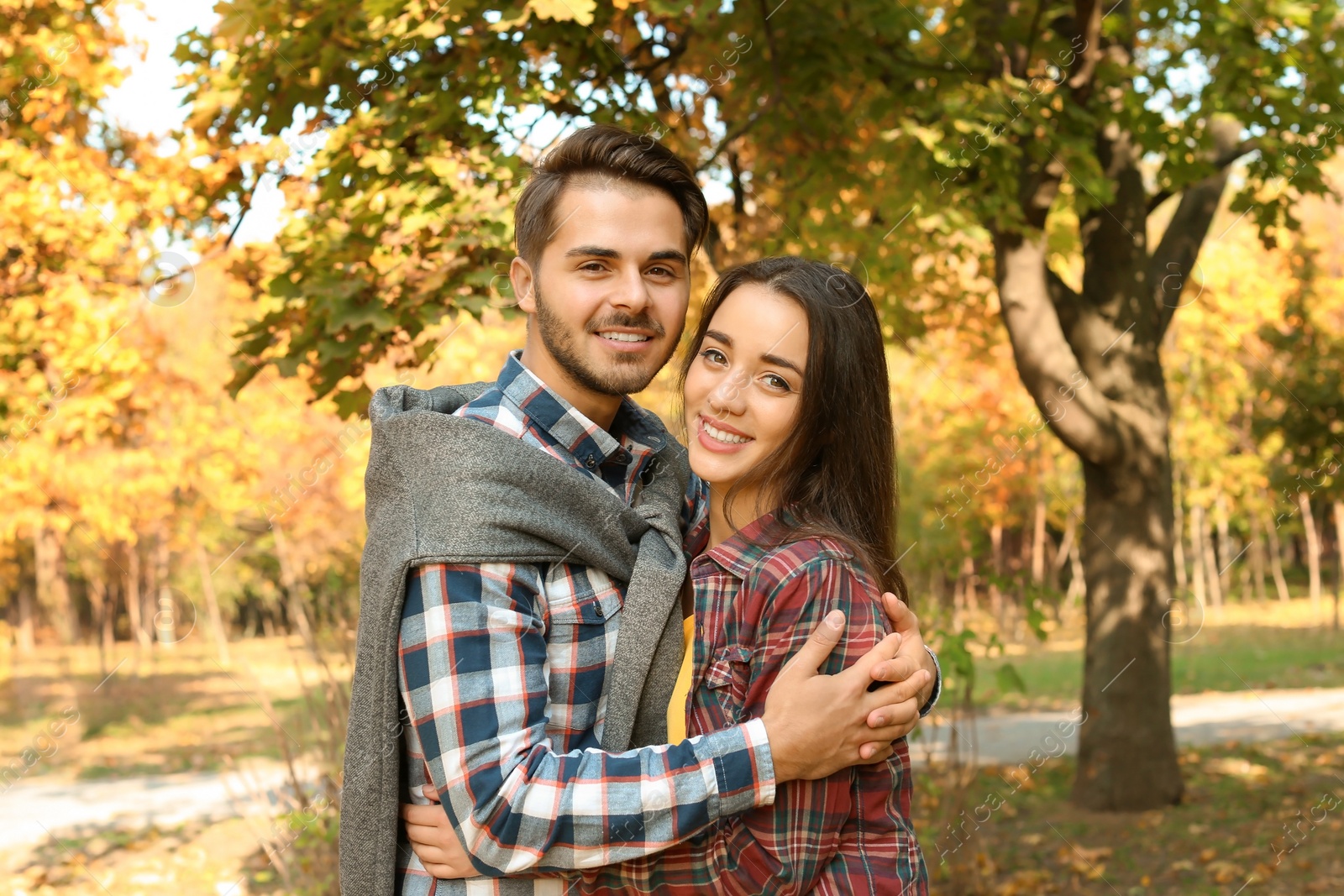 Photo of Young lovely couple spending time together in park. Autumn walk