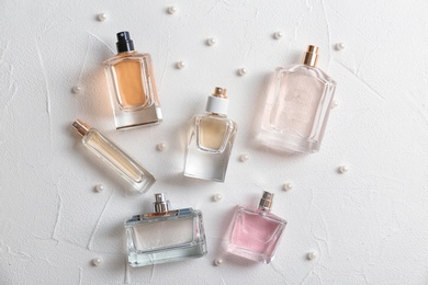 Photo of Beautiful composition with bottles of perfume on white background, flat lay