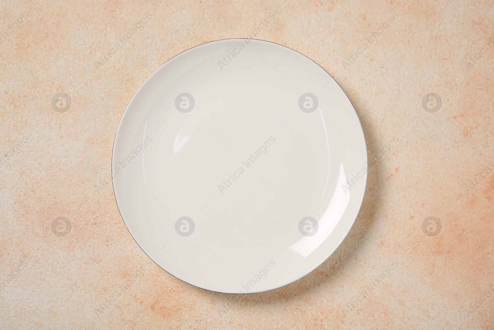 Photo of One ceramic plate on beige table, top view