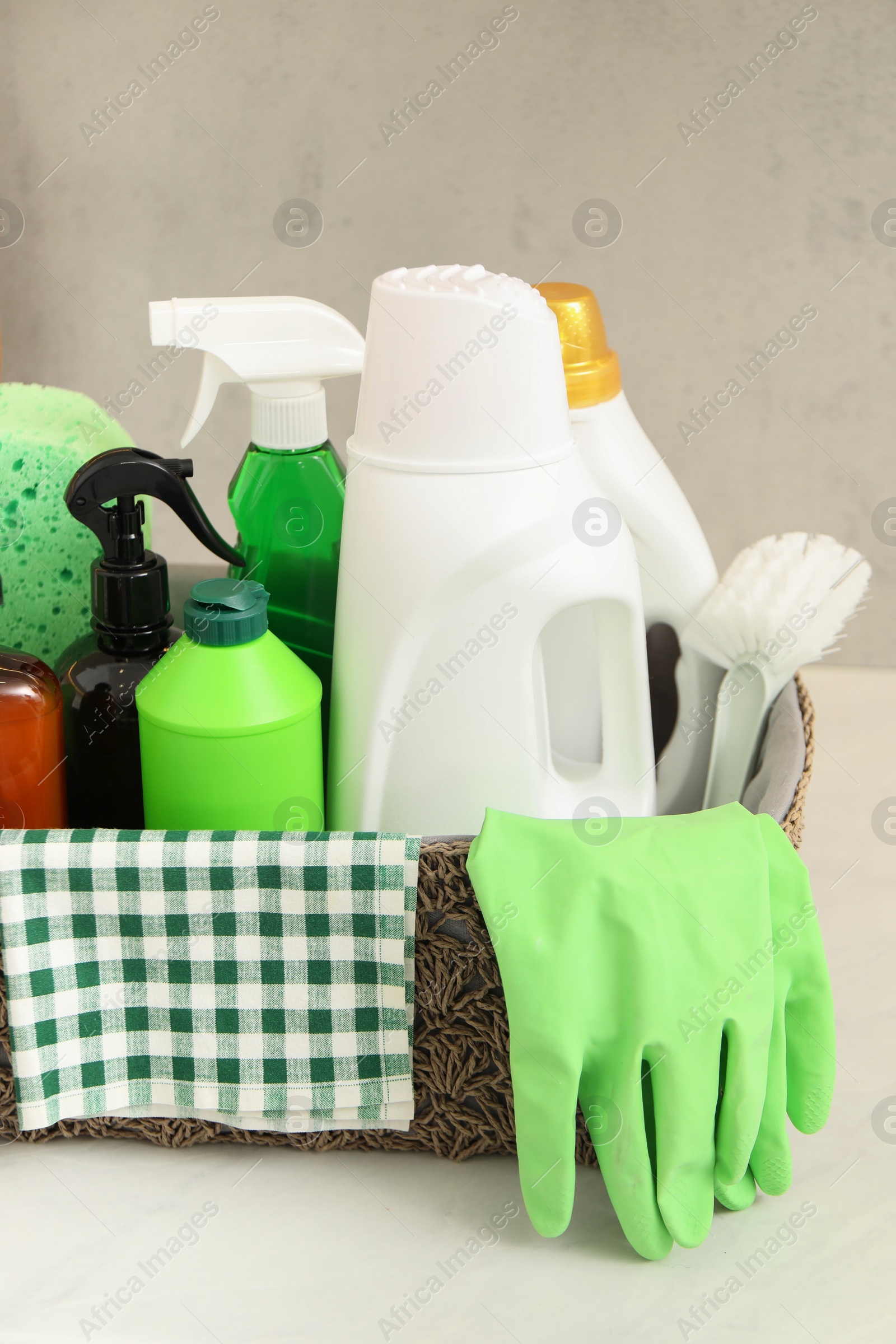 Photo of Different cleaning supplies in basket on countertop