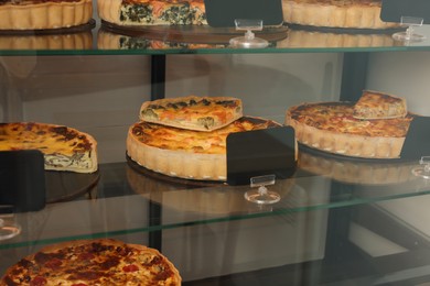 Different delicious quiches on counter in store
