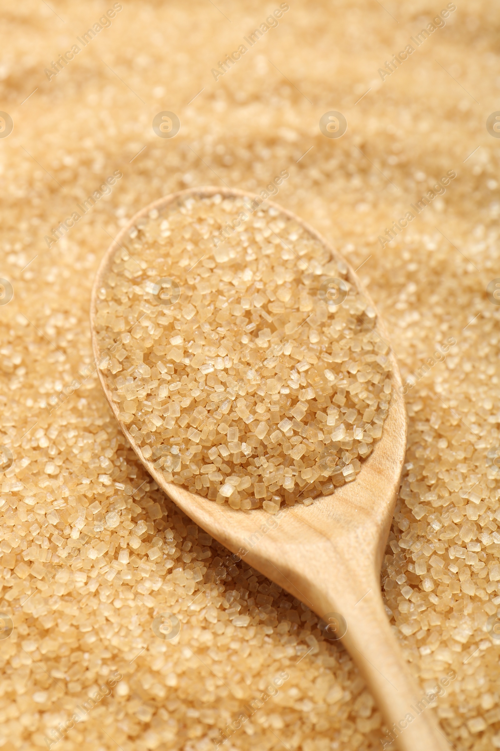 Photo of Spoon on granulated brown sugar, closeup view