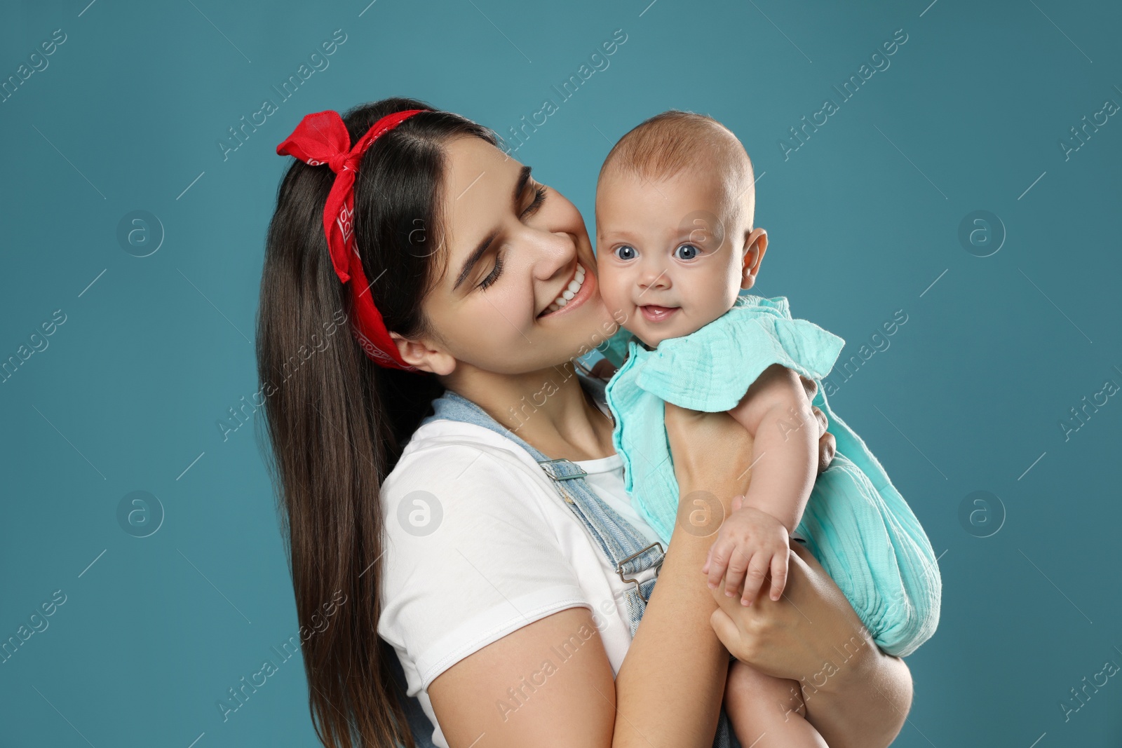 Photo of Beautiful mother with her cute baby on blue background