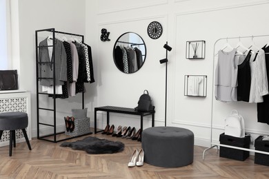 Photo of Dressing room with stylish clothes, shoes and accessories. Elegant interior design