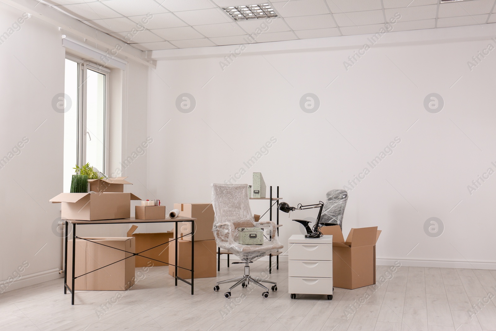 Photo of Carton boxes with stuff in room. Office move concept