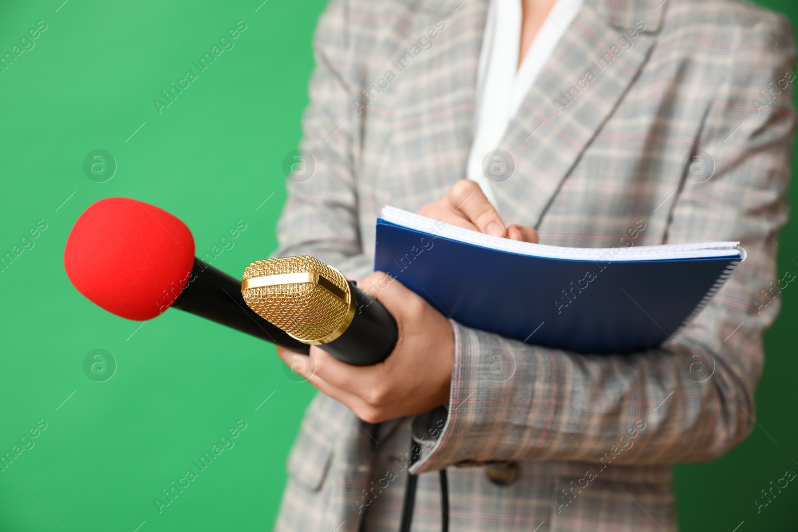 Photo of Journalist with microphones and notebook on green background, closeup