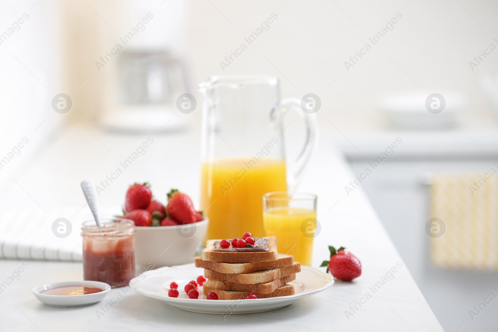 Photo of Toasted bread with chocolate spread and cranberries on white table in kitchen