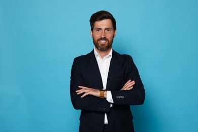 Photo of Portrait of handsome bearded man in suit on light blue background