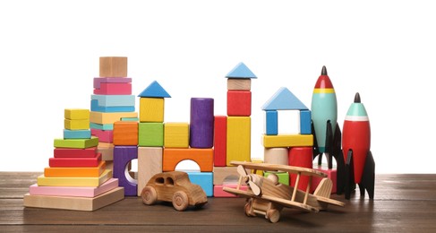 Set of different toys on wooden table against white background