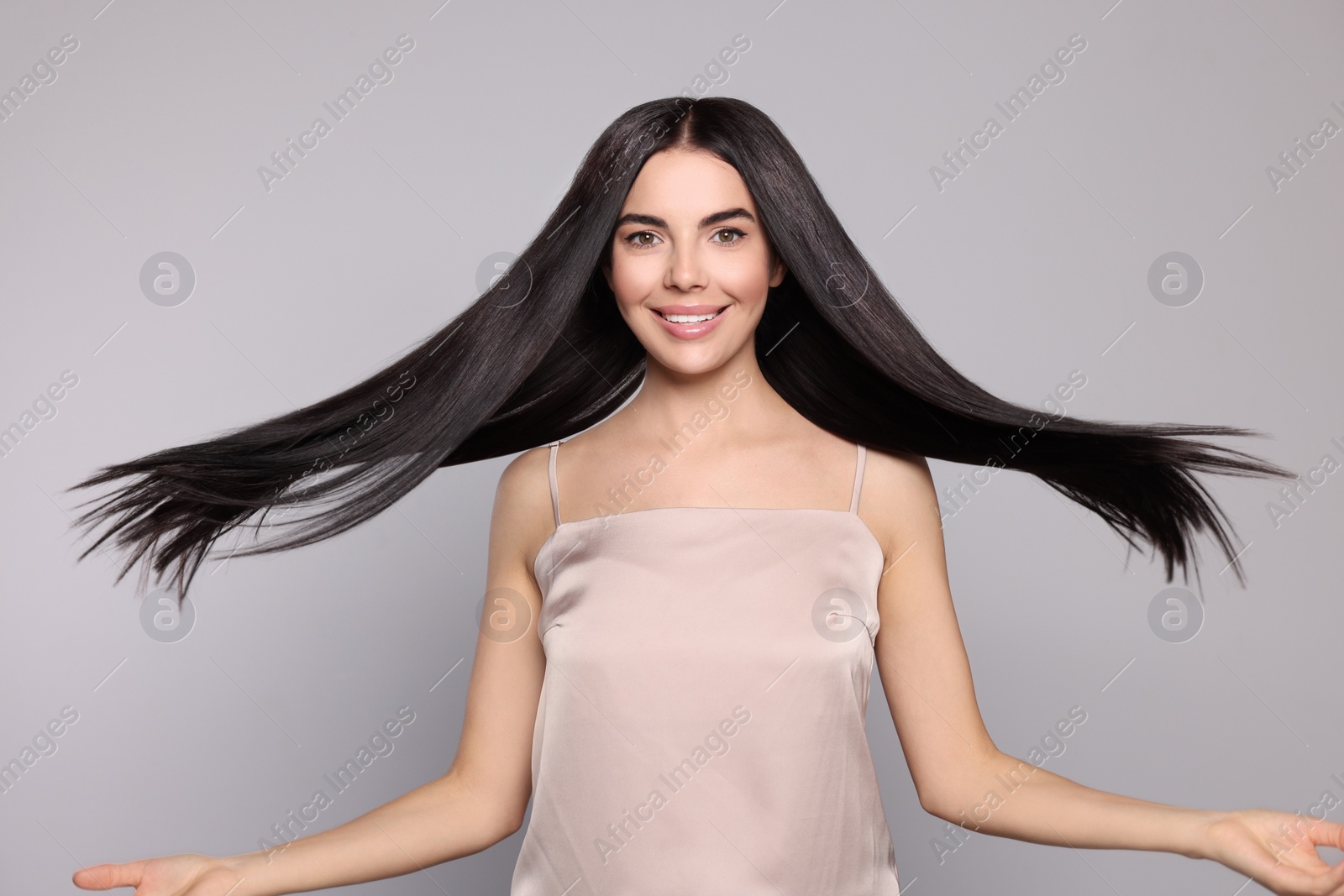 Photo of Portrait of beautiful young woman with healthy strong hair on light grey background