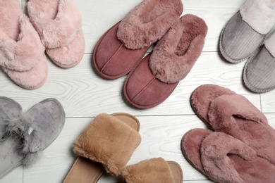 Photo of Many different soft slippers on white wooden background, flat lay