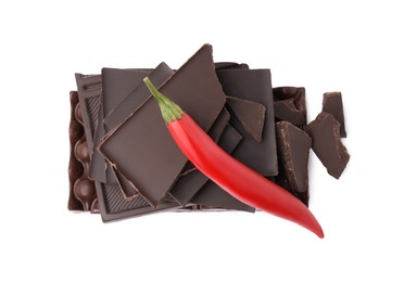 Photo of Red hot chili pepper and pieces of dark chocolate isolated on white, top view