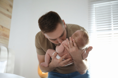 Photo of Father with his newborn son at home