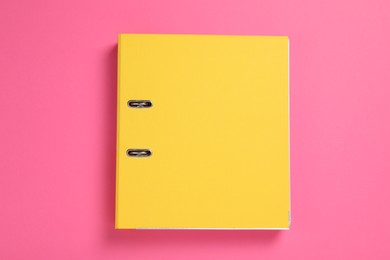 Photo of Yellow office folder on pink background, top view