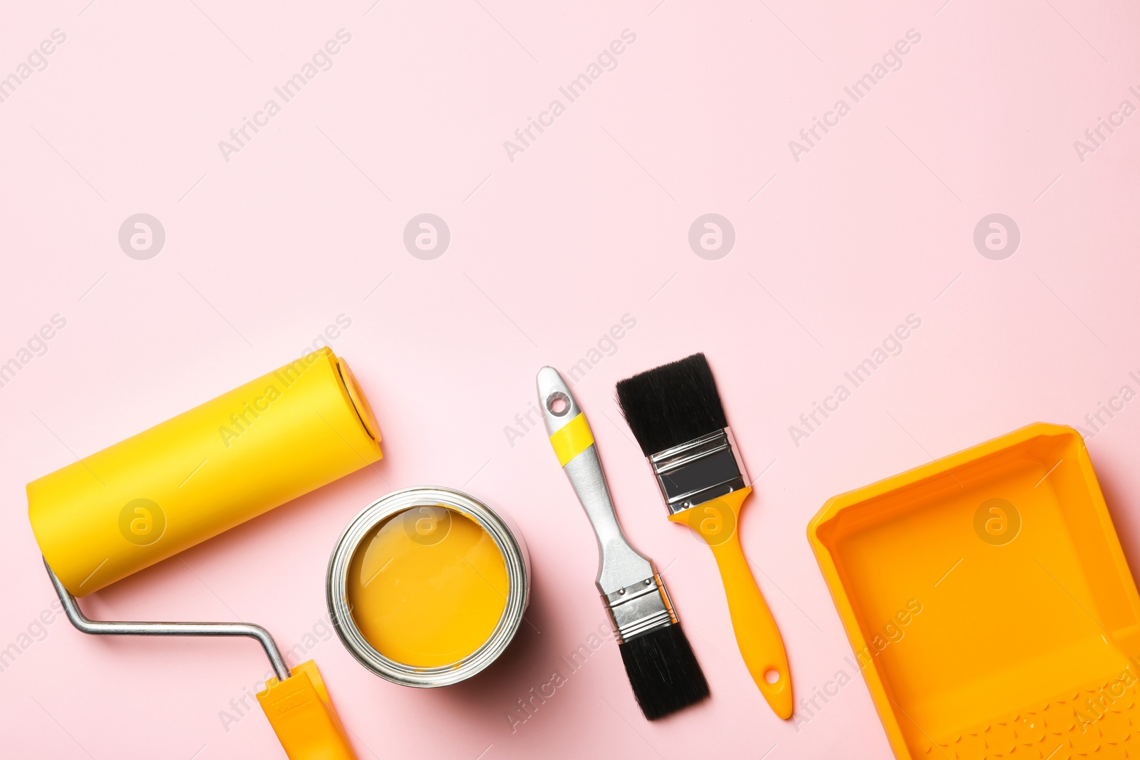 Photo of Flat lay composition with paint can, decorator tools and space for text on color background