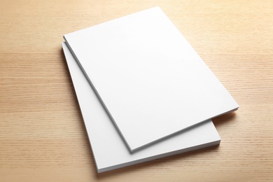 Stack of blank paper sheets for brochure on wooden background. Mock up