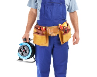 Photo of Electrician with extension cord reel and tools wearing uniform on white background, closeup