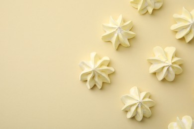 Delicious meringue cookies on beige background, flat lay. Space for text