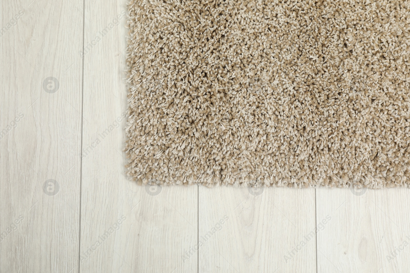 Photo of Soft beige carpet on white laminated floor indoors, top view