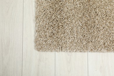 Photo of Soft beige carpet on white laminated floor indoors, top view