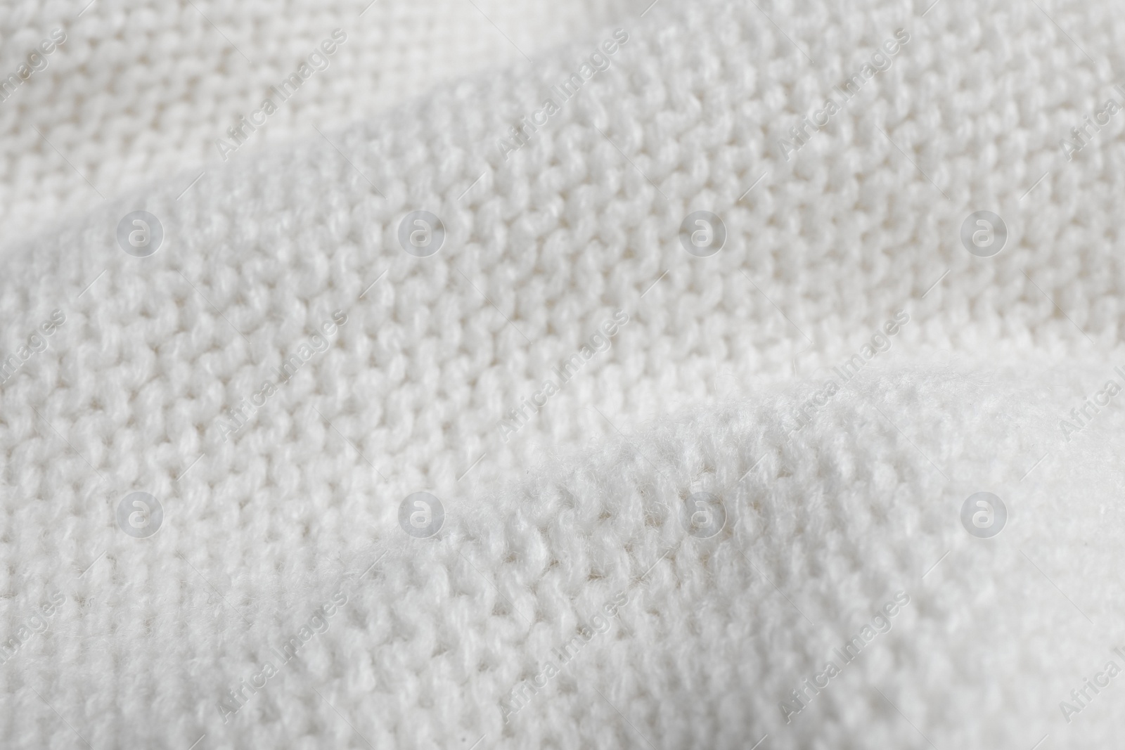 Photo of White knitted sweater as background, closeup view