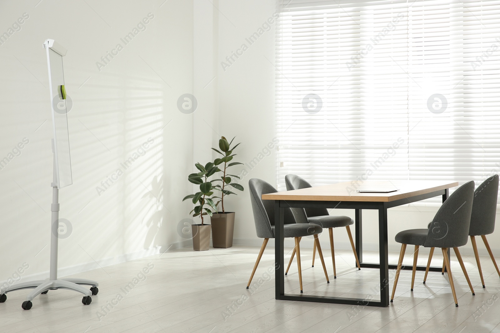 Photo of Conference room interior with wooden table and flipchart