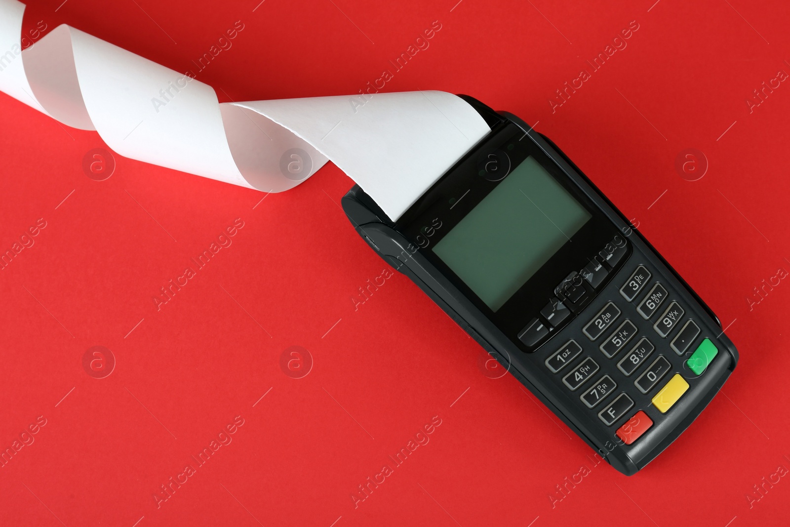Photo of New modern payment terminal with blank paper bill on red background, top view