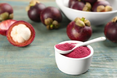 Purple mangosteen powder and fruits on light blue wooden table