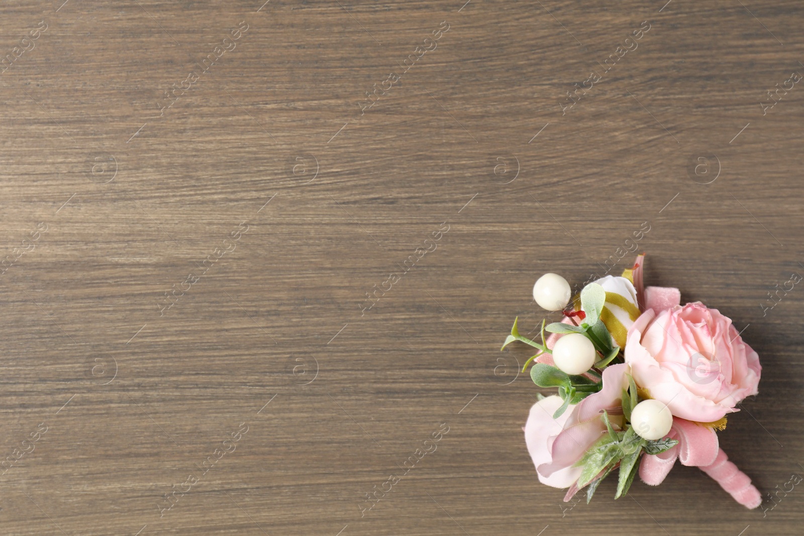 Photo of Beautiful boutonniere on wooden background, top view. Space for text