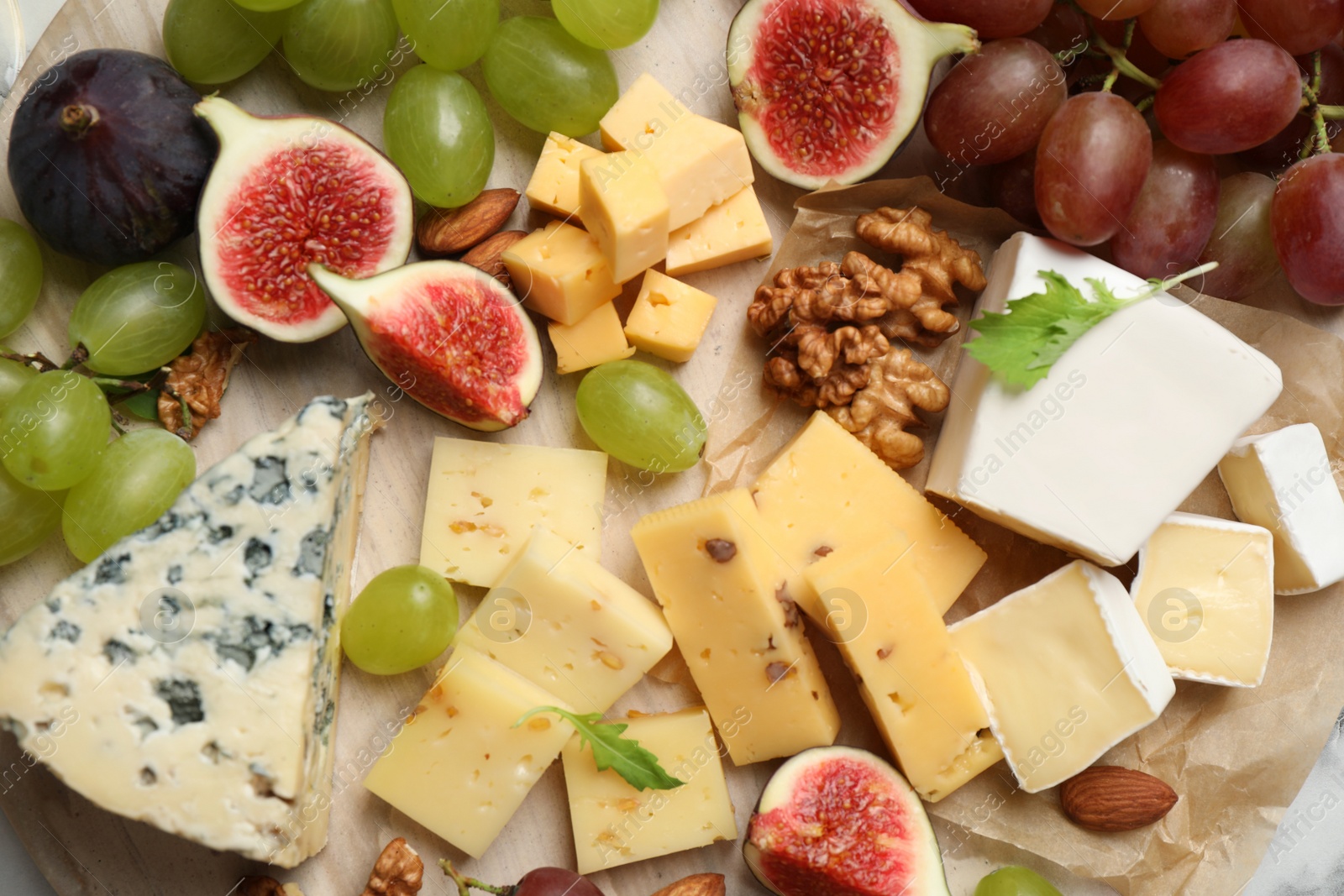 Photo of Set of different snacks with ripe figs served on board, closeup