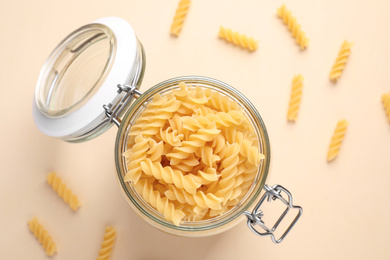 Fusilli pasta on beige background, flat lay