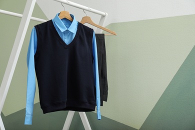 Photo of School uniform for boy on rack against color background