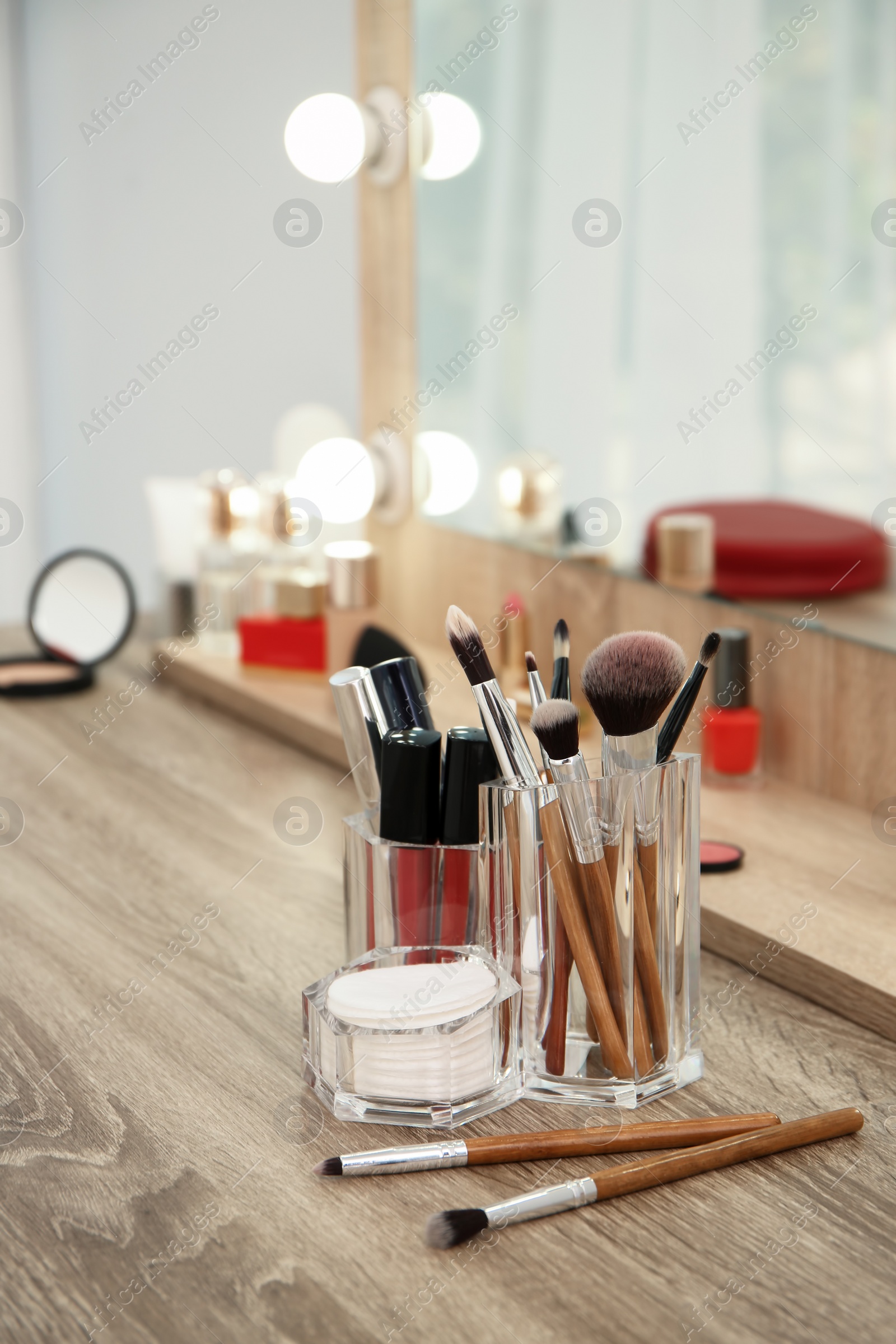 Photo of Makeup cosmetic products and tools on dressing table