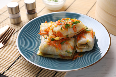 Photo of Delicious cabbage rolls served on white wooden table