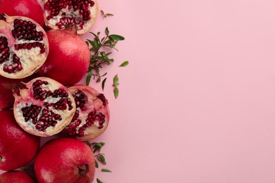 Flat lay composition with ripe pomegranates on pink background. Space for text