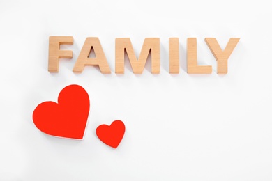 Word Family made of wooden letters and red hearts on white background